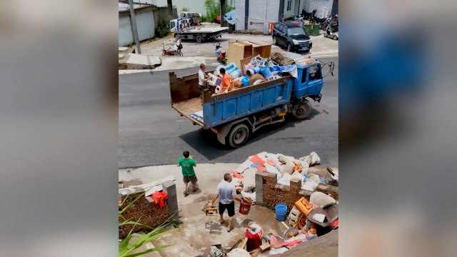 寺から持ち出された品物が、ごみ収集車に積み込まれる